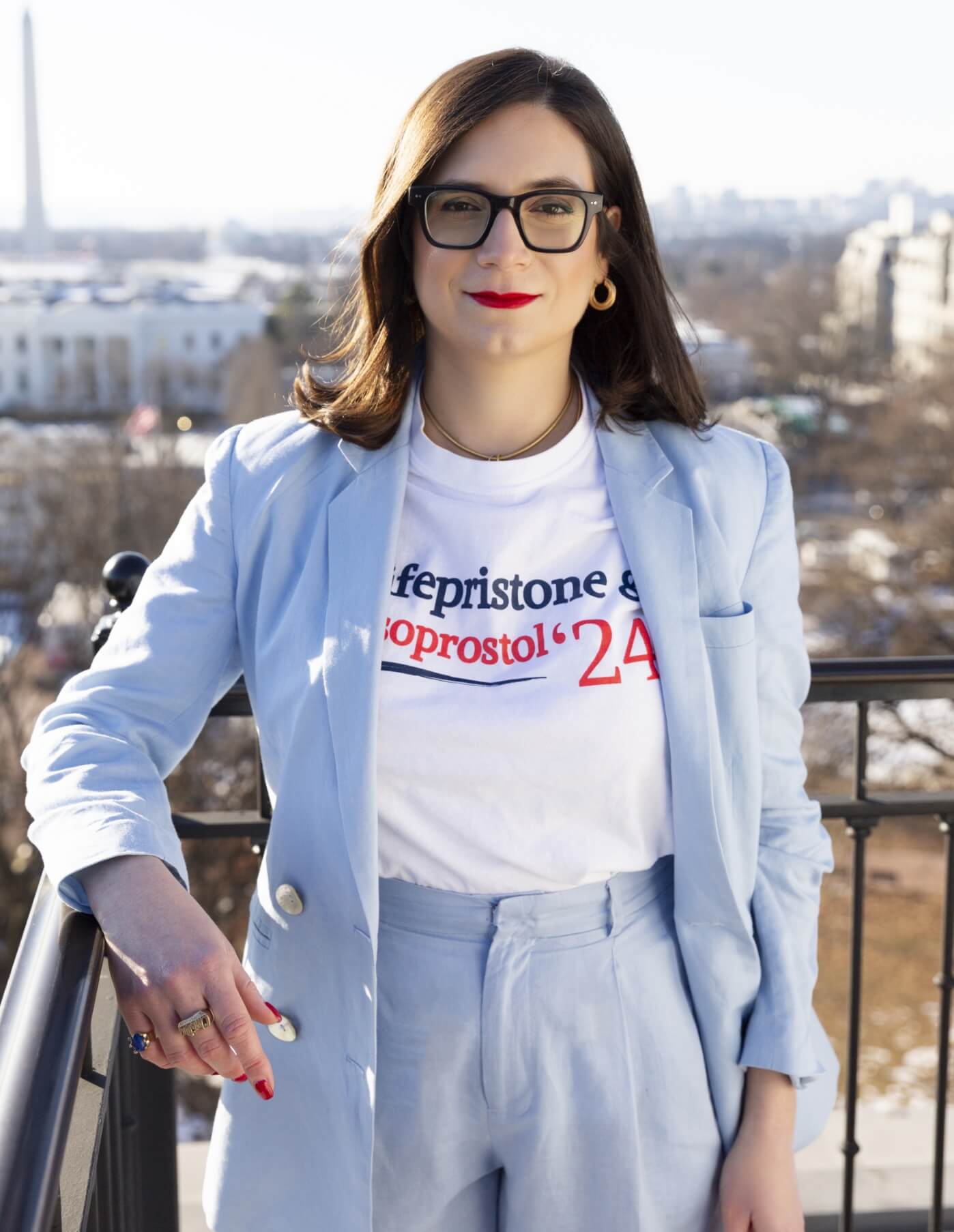 Christine poses in a Palmetto State Abortion Fund shirt with the campaign slogan for “Mifepristone & Misoprostol ‘24”—the safe, effective two-medication regimen for a self-managed abortion—on a rooftop above the White House.